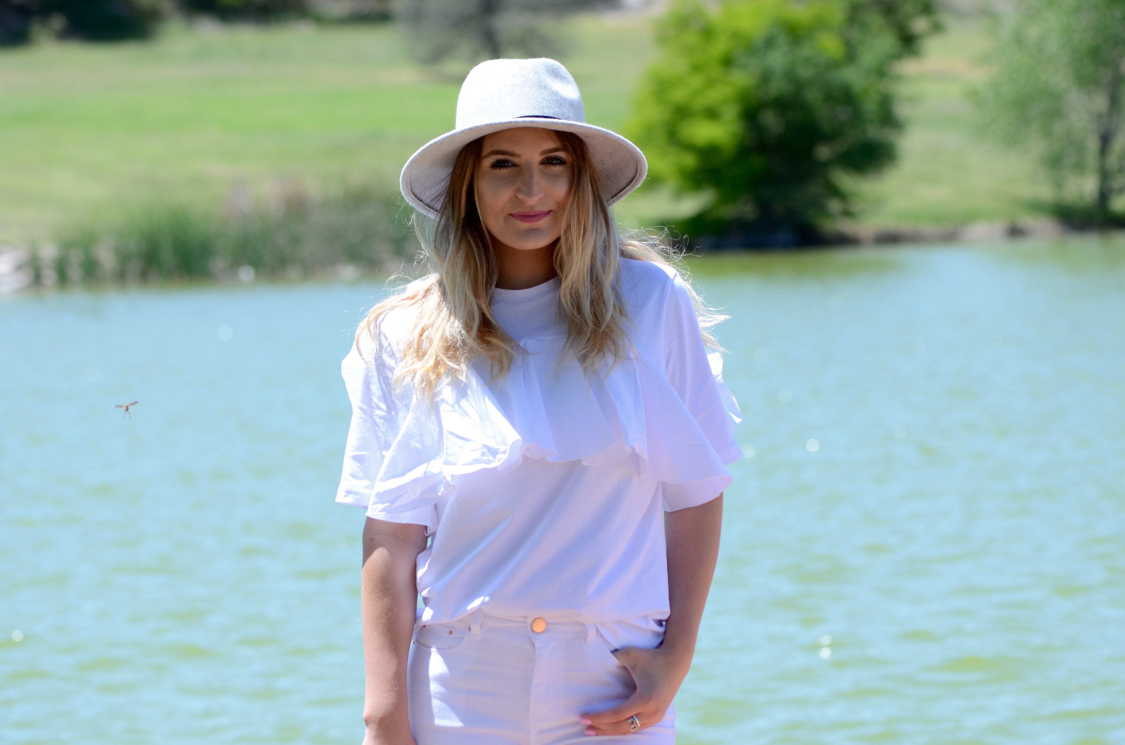 grey felt hat and an all white outfit