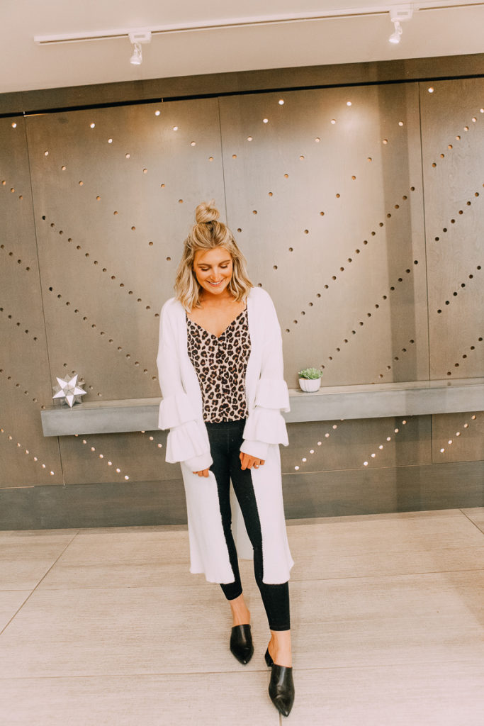 How To Style Leggings For Work featured by top US fashion blogger Audrey Madison Stowe; Image of a woman wearing a Aria Rose leopard tank and Nordstrom Rack long white duster.