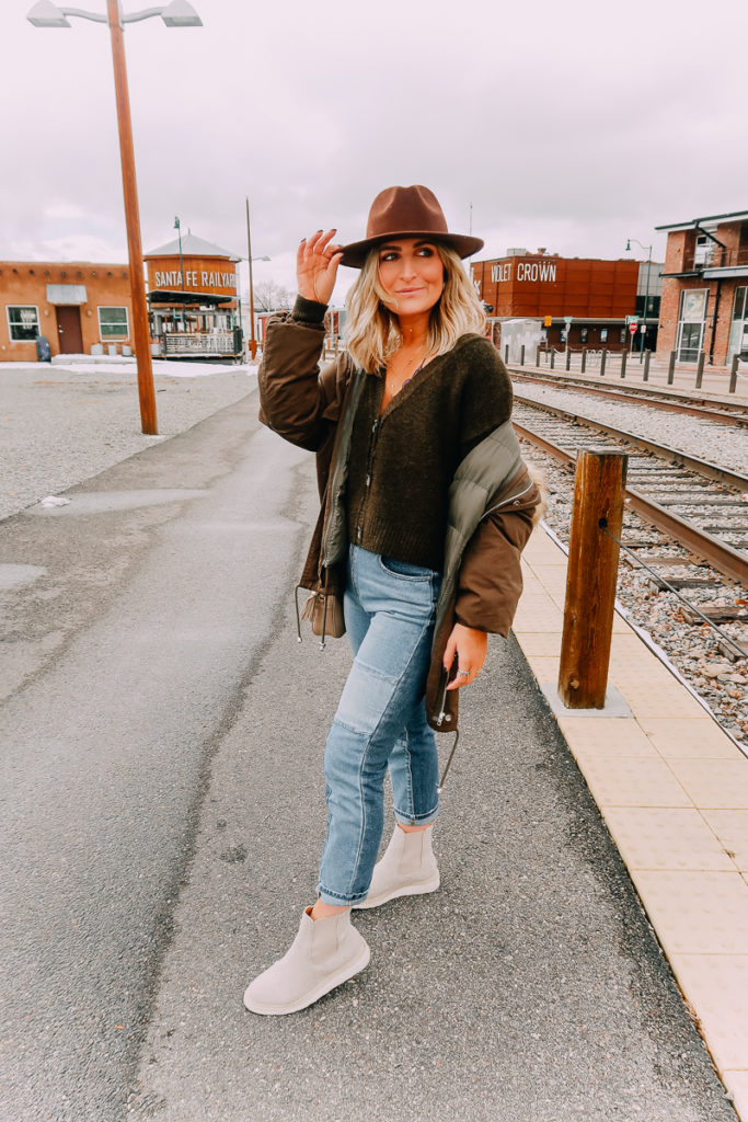 Santa Fe Weekend featured by top US travel blogger Audrey Madison Stowe; Image of woman at a train station wearing a hat.