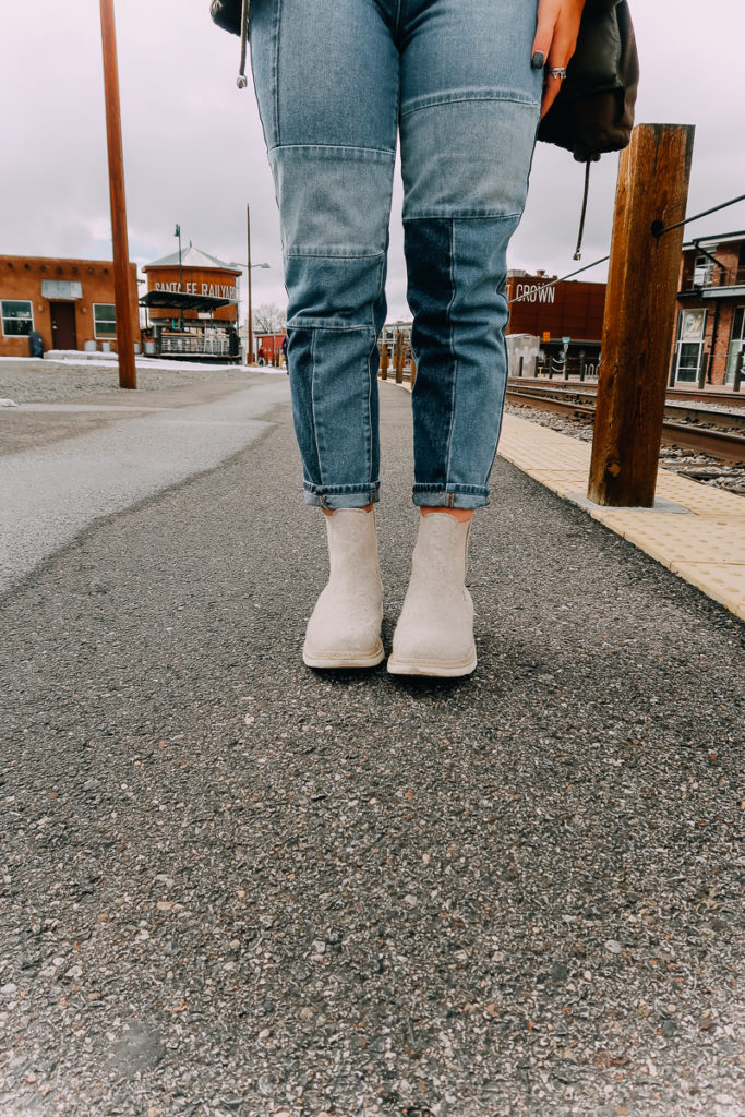 How To Cuff Women's Jeans featured by top US fashion blogger Audrey Madison Stowe; Woman fixing her jeans.