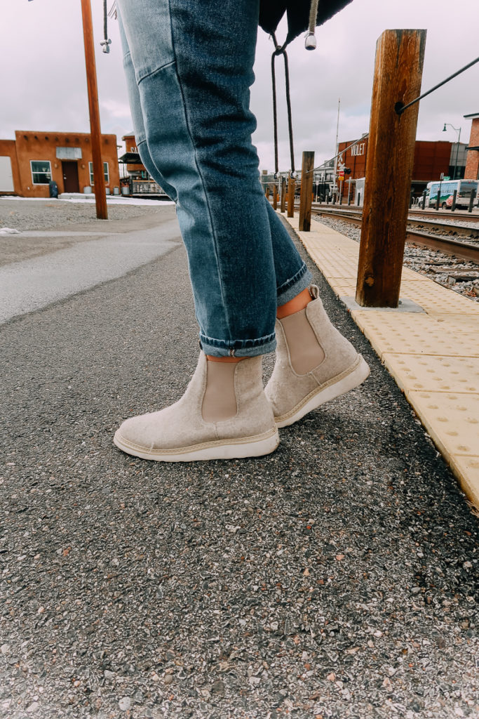 How To Cuff Women's Jeans featured by top US fashion blogger Audrey Madison Stowe; Woman fixing her jeans.