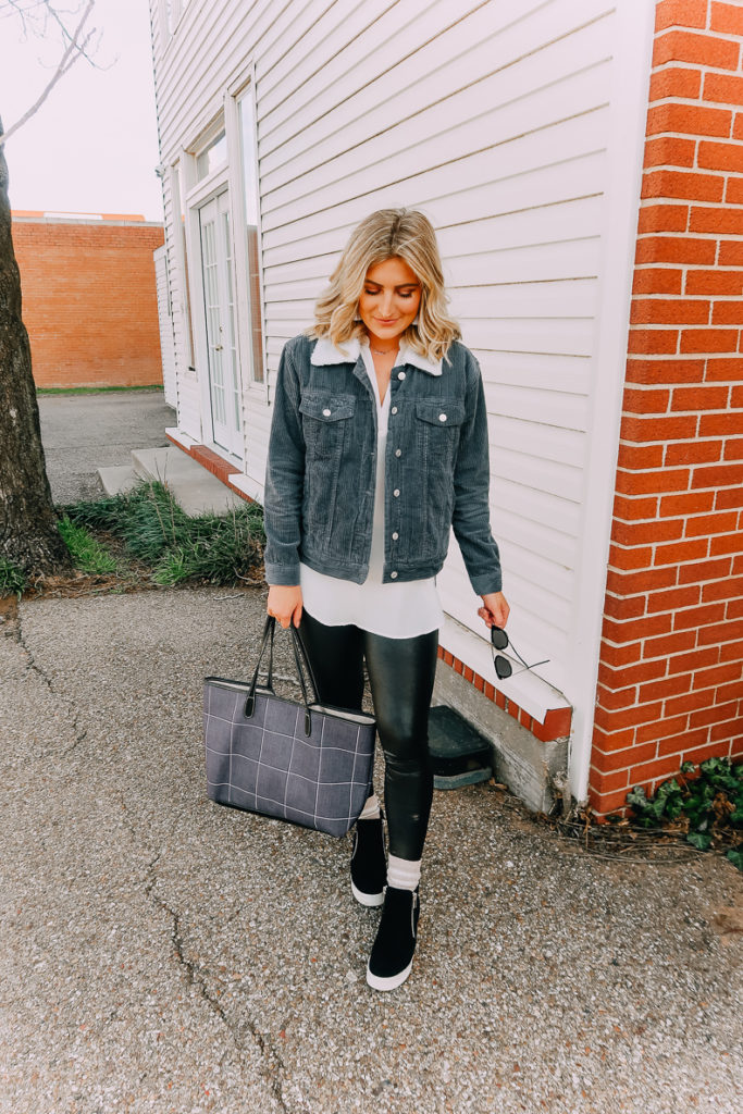 Ways To Wear a White Blouse featured by top US fashion blogger Audrey Madison Stowe; Image of woman wearing white blouse, denim jacket, faux leather leggings and Steve Madden wedges.