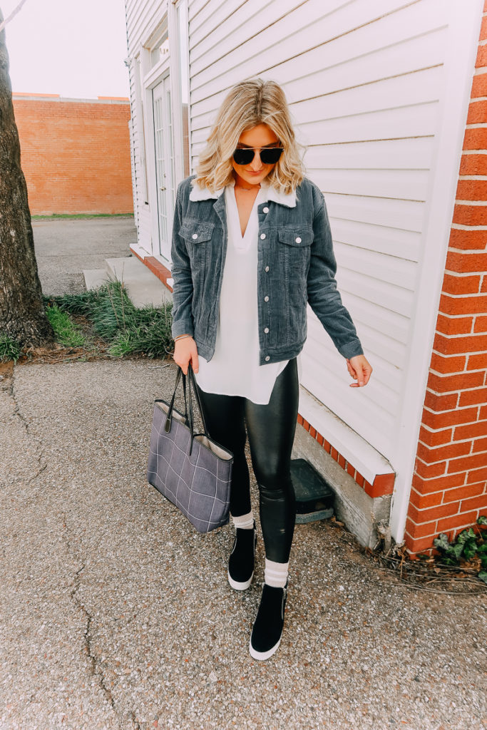 Ways To Wear a White Blouse featured by top US fashion blogger Audrey Madison Stowe; Image of woman wearing white blouse, denim jacket, faux leather leggings and Steve Madden wedges.