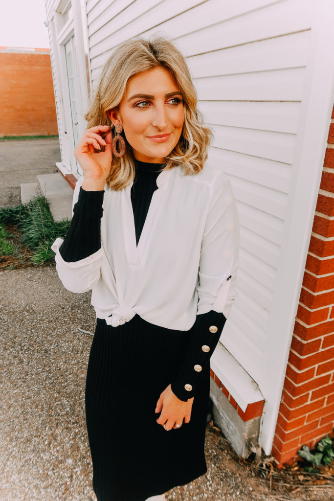 Ways To Wear a White Blouse featured by top US fashion blogger Audrey Madison Stowe; Image of woman wearing white blouse and black midi sweater dress.